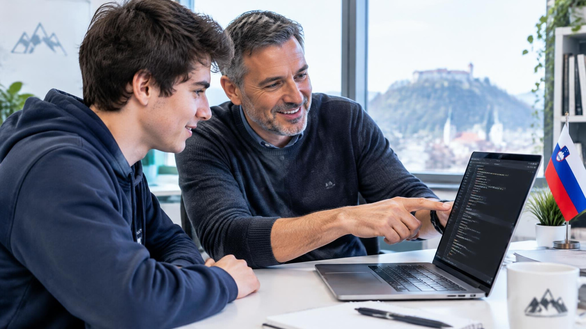 Two people reviewing code on a laptop together