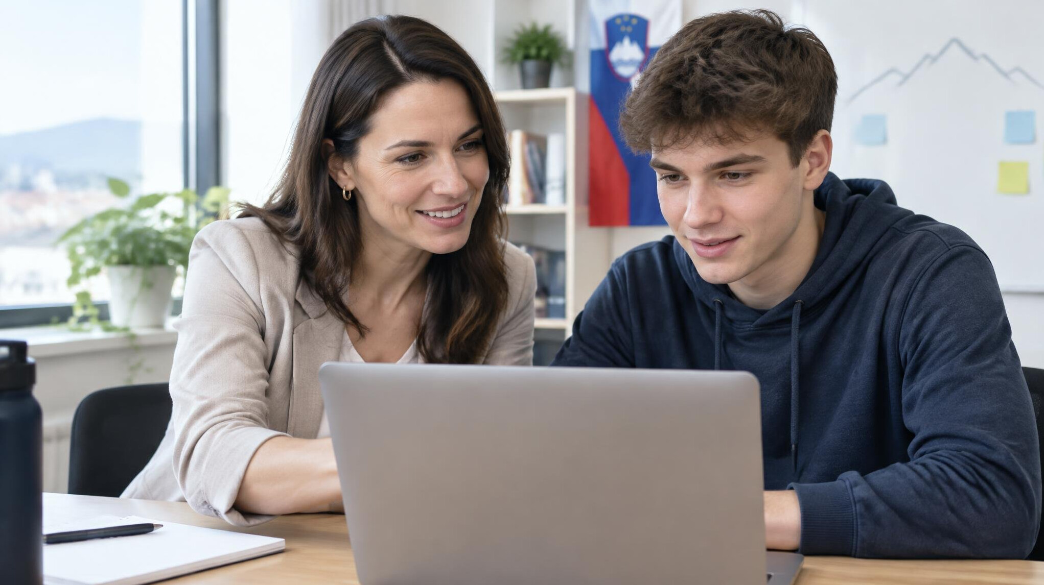 Mentor and student working together at a desk with laptop